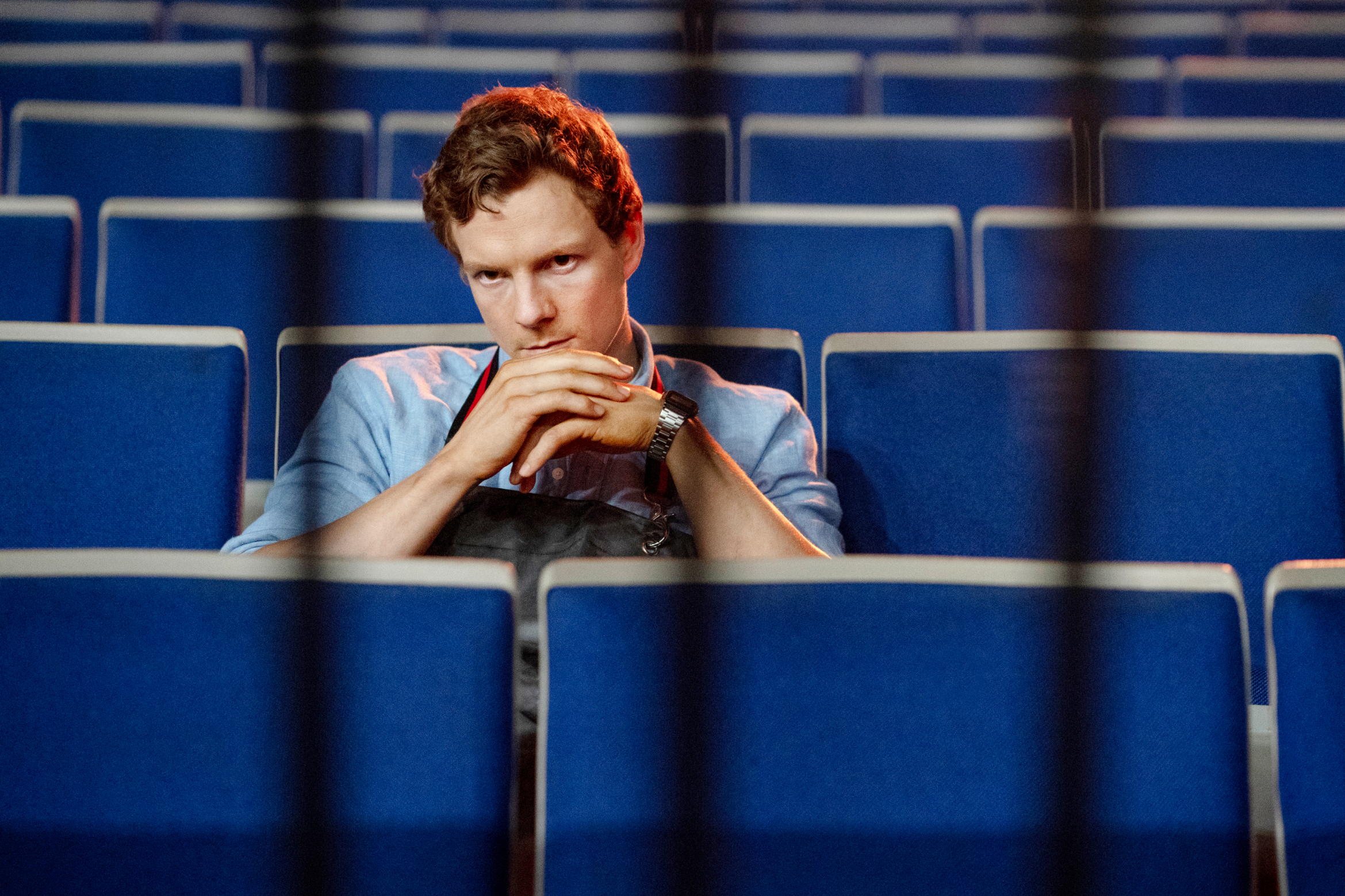A young Dexter Morgan, played by Patrick Gibson, sitting an empty theater, framed by bars