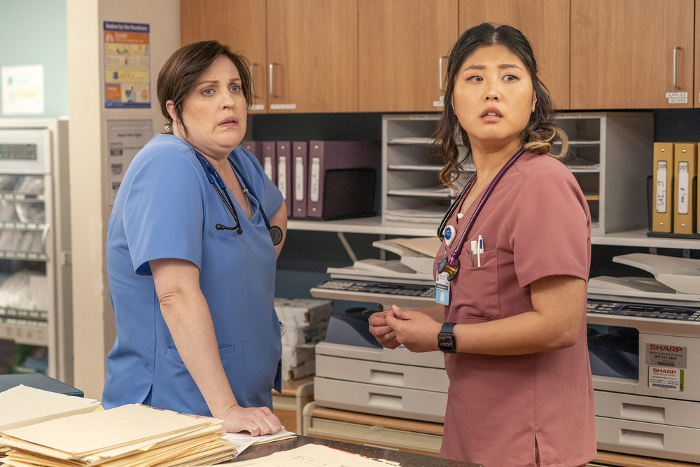 Allison Tolman and Kahyun Kim wearing scrubs in a hospital in a scene from "St. Denis Medical"