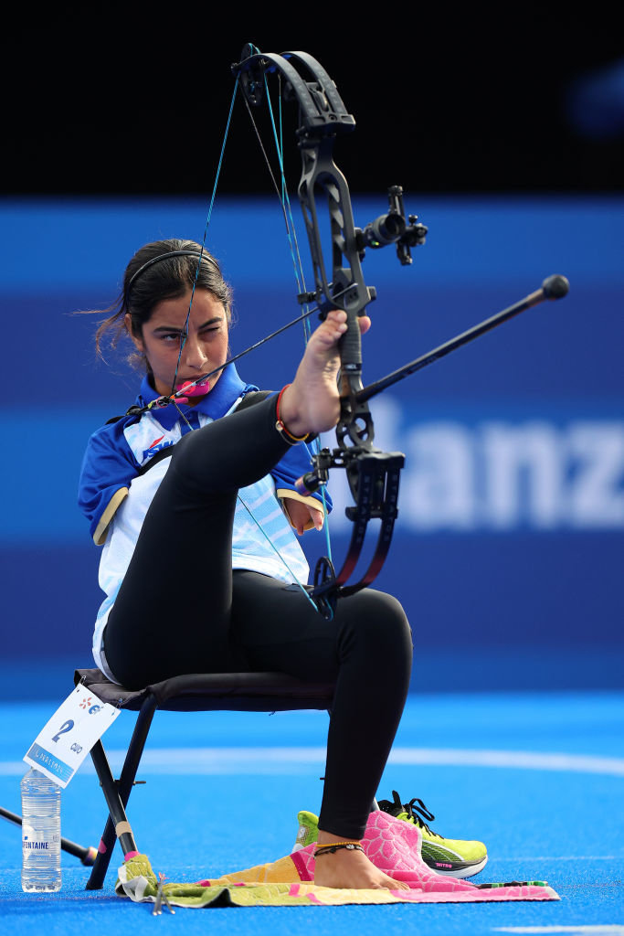 Sheetal Devi uses her feet to draw the bowstring while seated in her archery gear during a competition