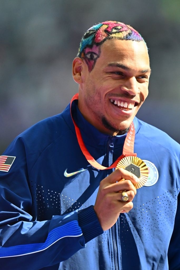 Roderick Townsend with colorful hair in eye pattern holding a medal and smiling