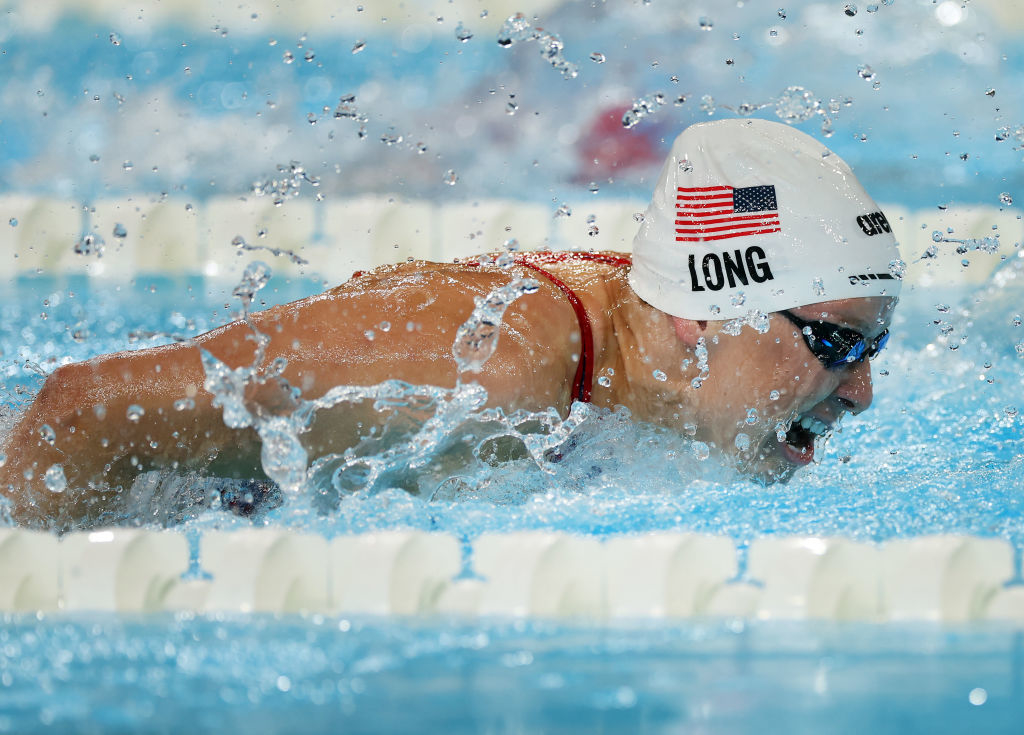 Jessica Long swimming in a competitive race, wearing a swim cap with the USA flag and her name