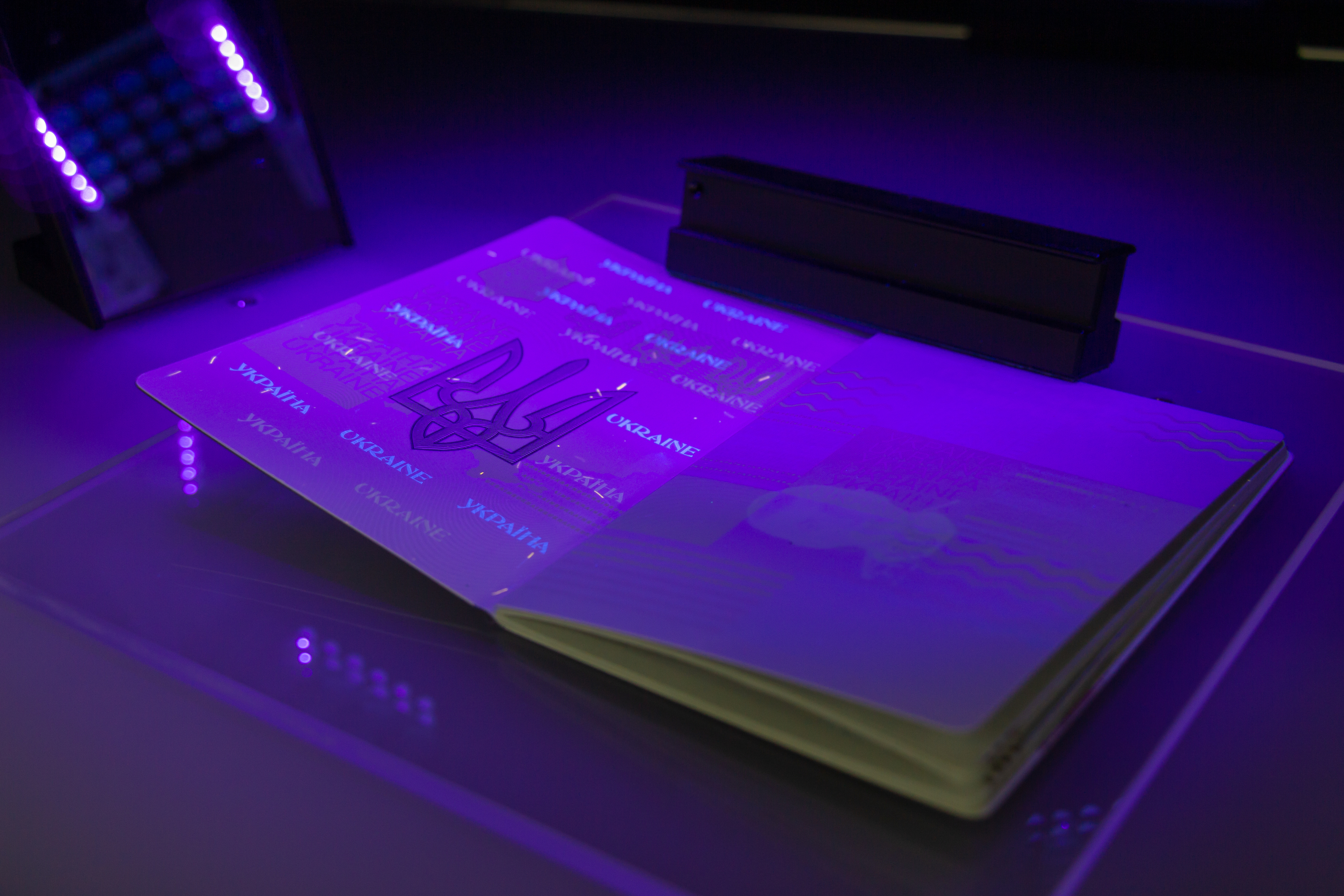 Open passport under UV light showing security features and patterns