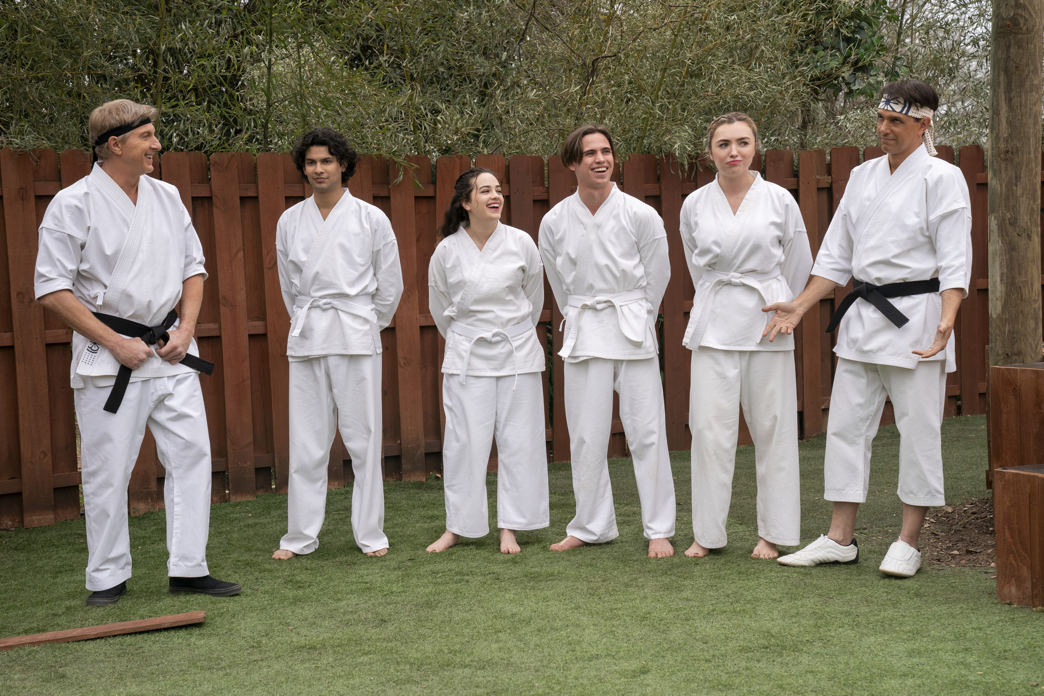 William Zabka and cast members of "Cobra Kai" wear karate gis during a scene set in a yard