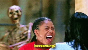 Regina Hall screams in fright as she looks at a person dressed as a skeleton. The subtitle reads "screaming."
