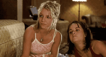 Britney Spears and Taryn Manning are sitting on the floor, casually dressed, in a relaxed indoor setting