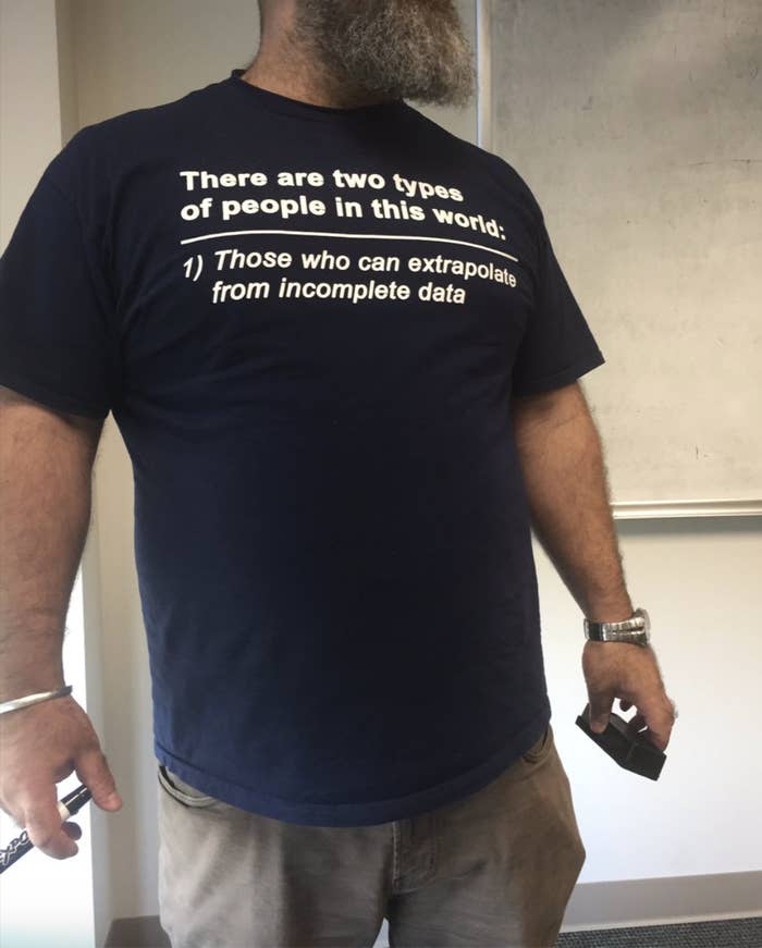 A person wearing a T-shirt with the text "There are two types of people in this world: 1) Those who can extrapolate from incomplete data."