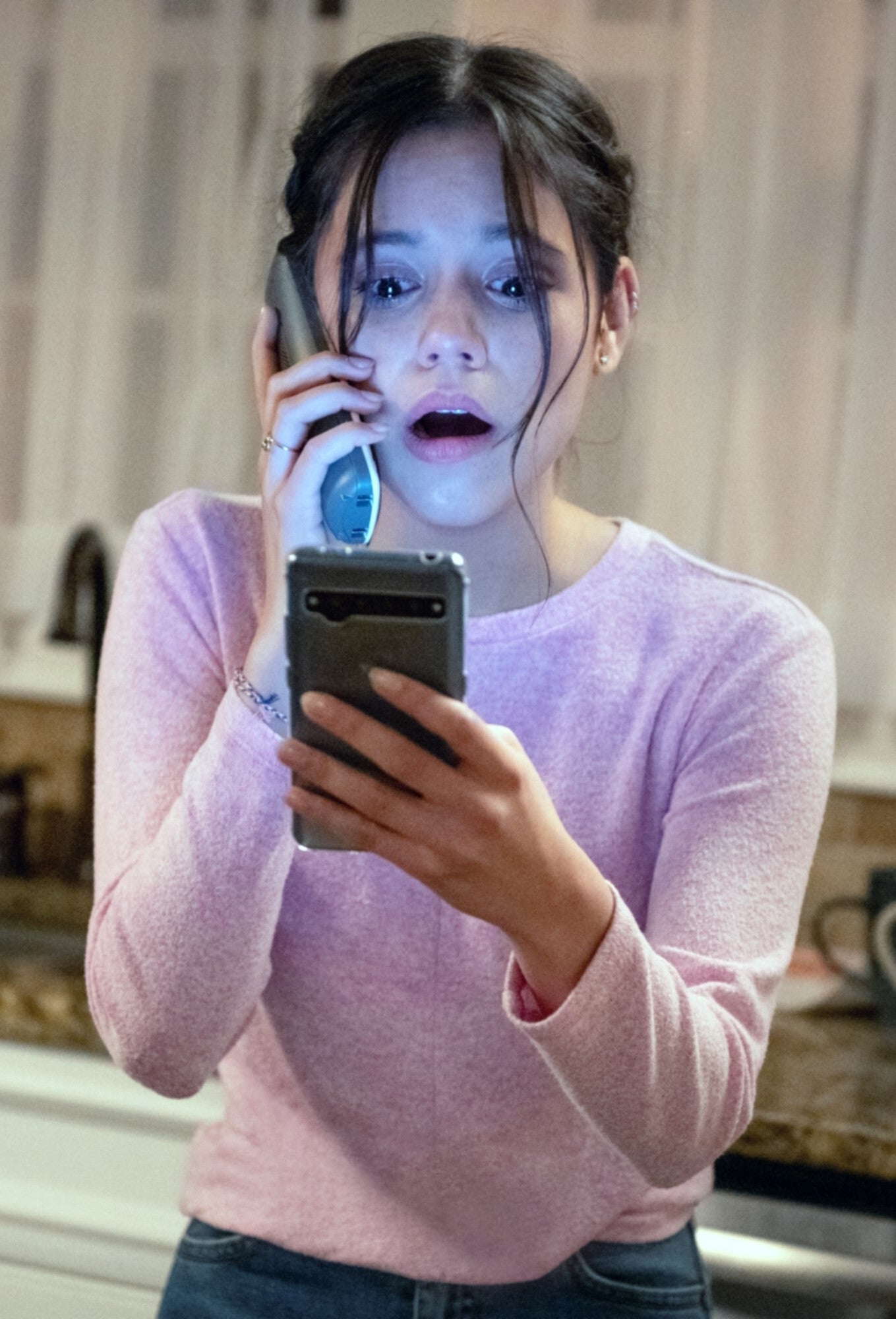 Jenna Ortega looking at a phone with a frightened expression in "Scream 5"