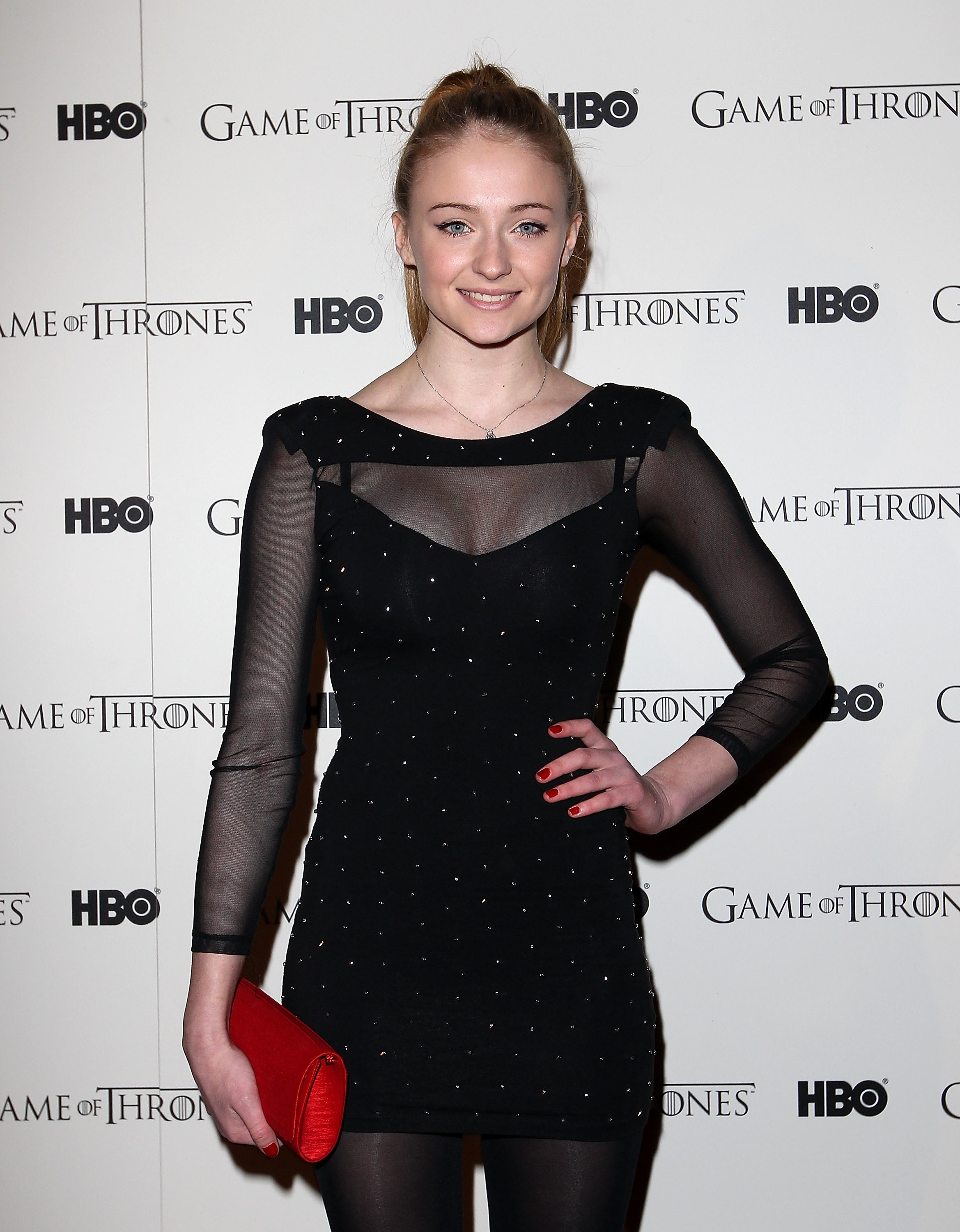 Sophie Turner on the red carpet in a stylish, sheer dark dress with a clutch, attending a &quot;Game of Thrones&quot; event