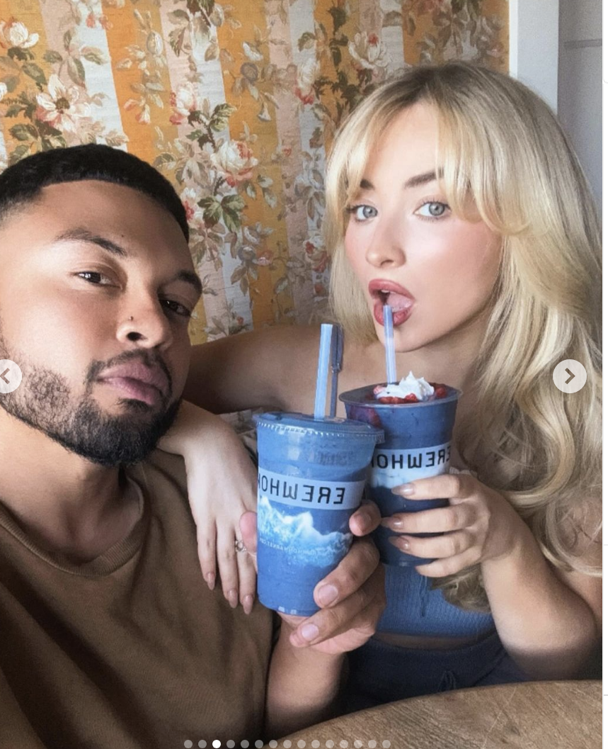 Alfredo Flores and Sabrina Carpenter holding Erewhon drinks with straws, posing for a selfie.