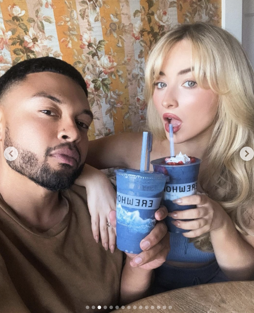 Alfredo Flores and Sabrina Carpenter holding Erewhon drinks with straws, posing for a selfie.