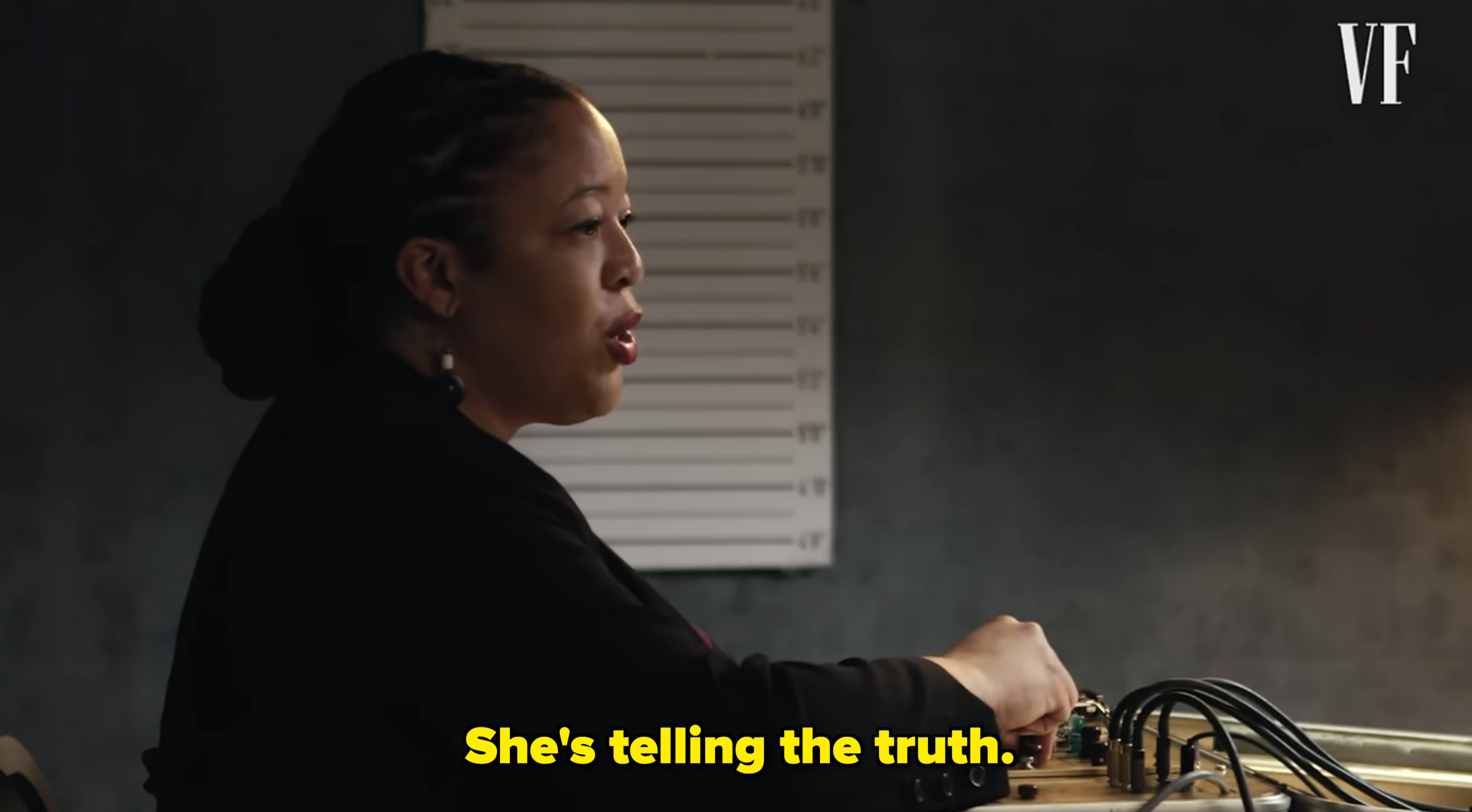 Woman in a dark blazer working at a sound mixing console with a VF logo in the corner