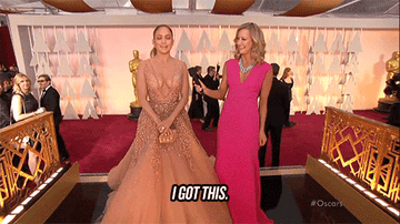 Jennifer Lopez in a ball gown and Lara Spencer in an elegant dress on the red carpet, with Jennifer confidently saying, &quot;I got this.&quot;