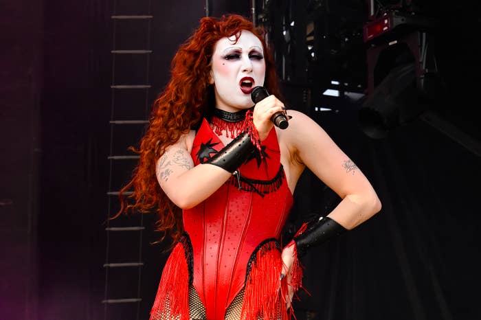 Chappell Roan passionately sings on stage in a red fringed bodysuit with black star designs