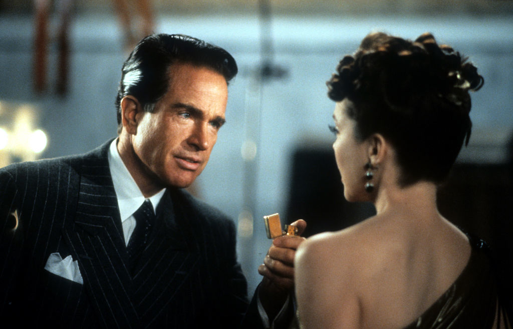 Warren Beatty and Annette Bening in a formal setting, with Warren Beatty holding a lighter towards Annette Bening