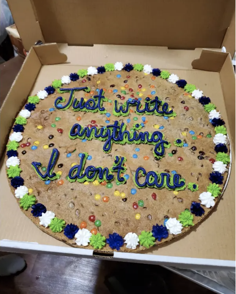 Large cookie cake with colorful frosting decorations reads, "Just write anything. I don't care."