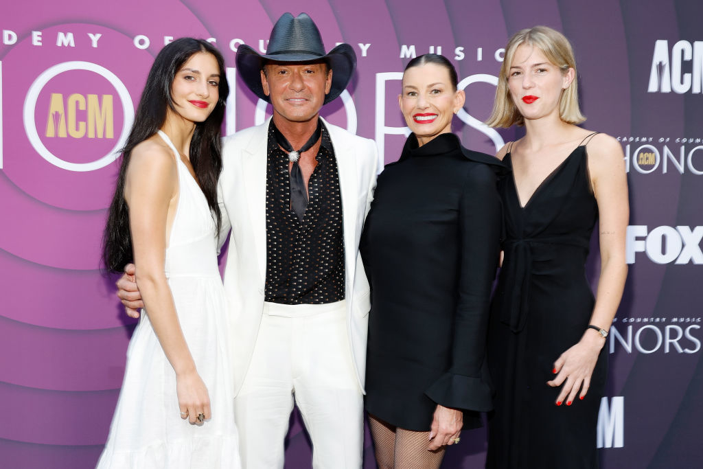 Tim McGraw in a white suit and black cowboy hat, Faith Hill in a black dress, and their daughters Maggie and Audrey in black and white dresses at the ACM Awards