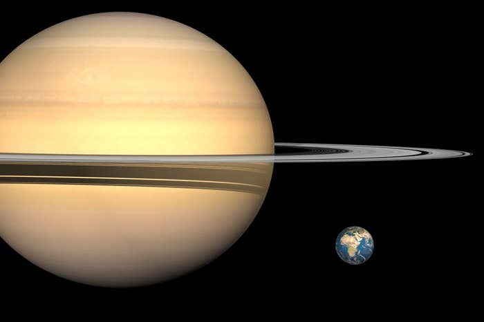 Saturn with its rings is shown next to Earth, emphasizing the size difference between the two planets