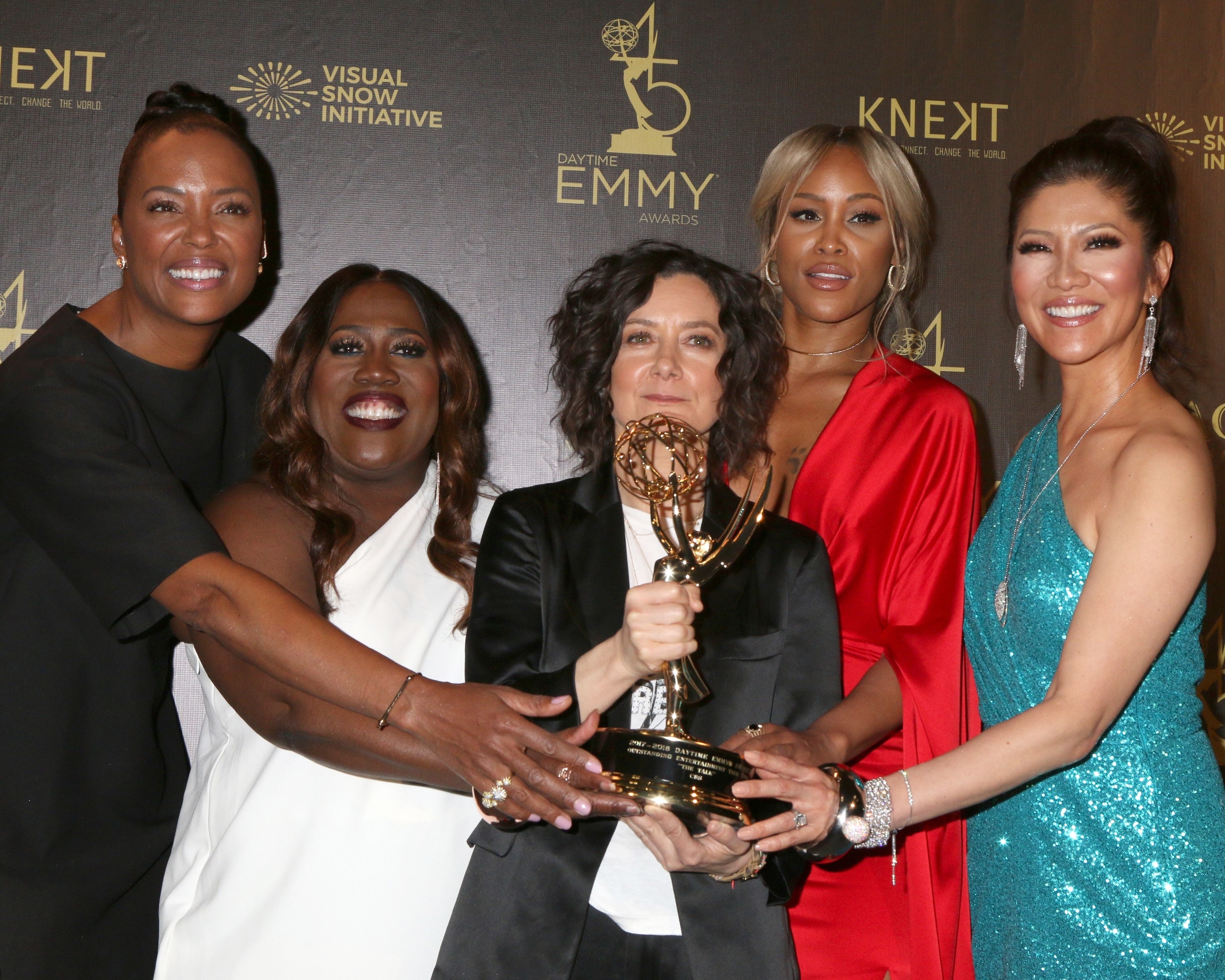 Aisha Tyler, Sheryl Underwood, Sara Gilbert, Eve, and Julie Chen Moonves at the Daytime Emmy Awards, holding an Emmy trophy together