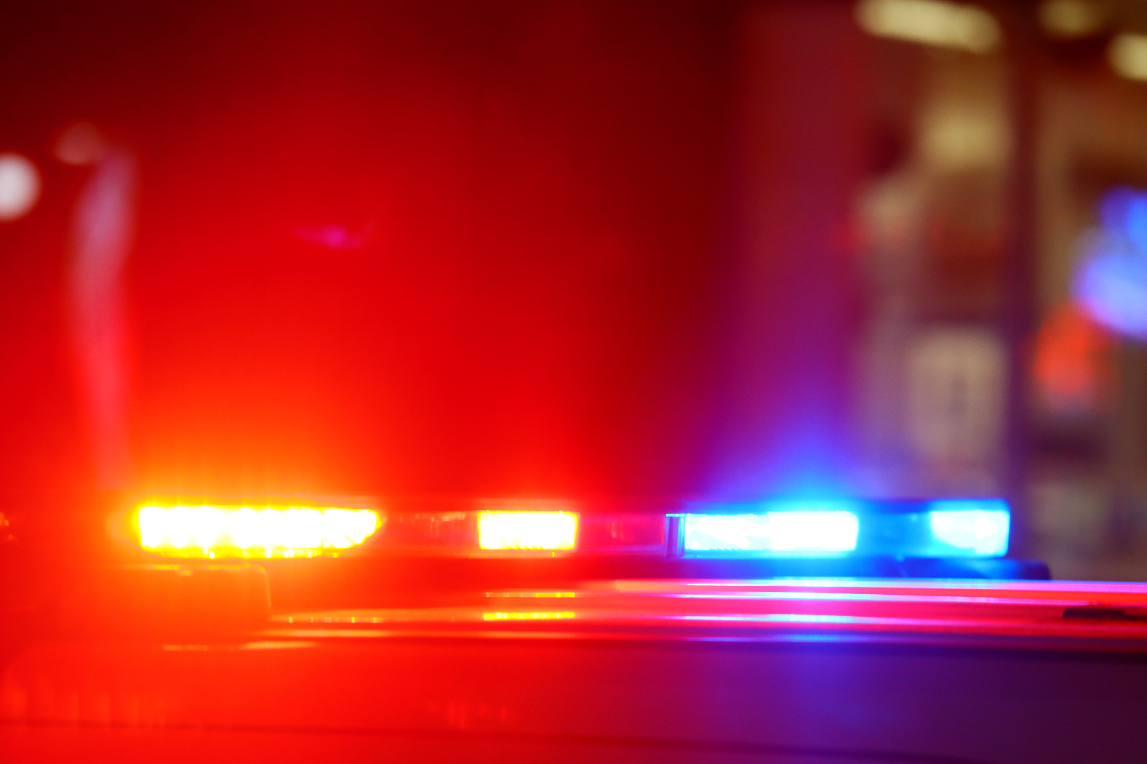 Flashing red and blue police lights on top of a vehicle at night