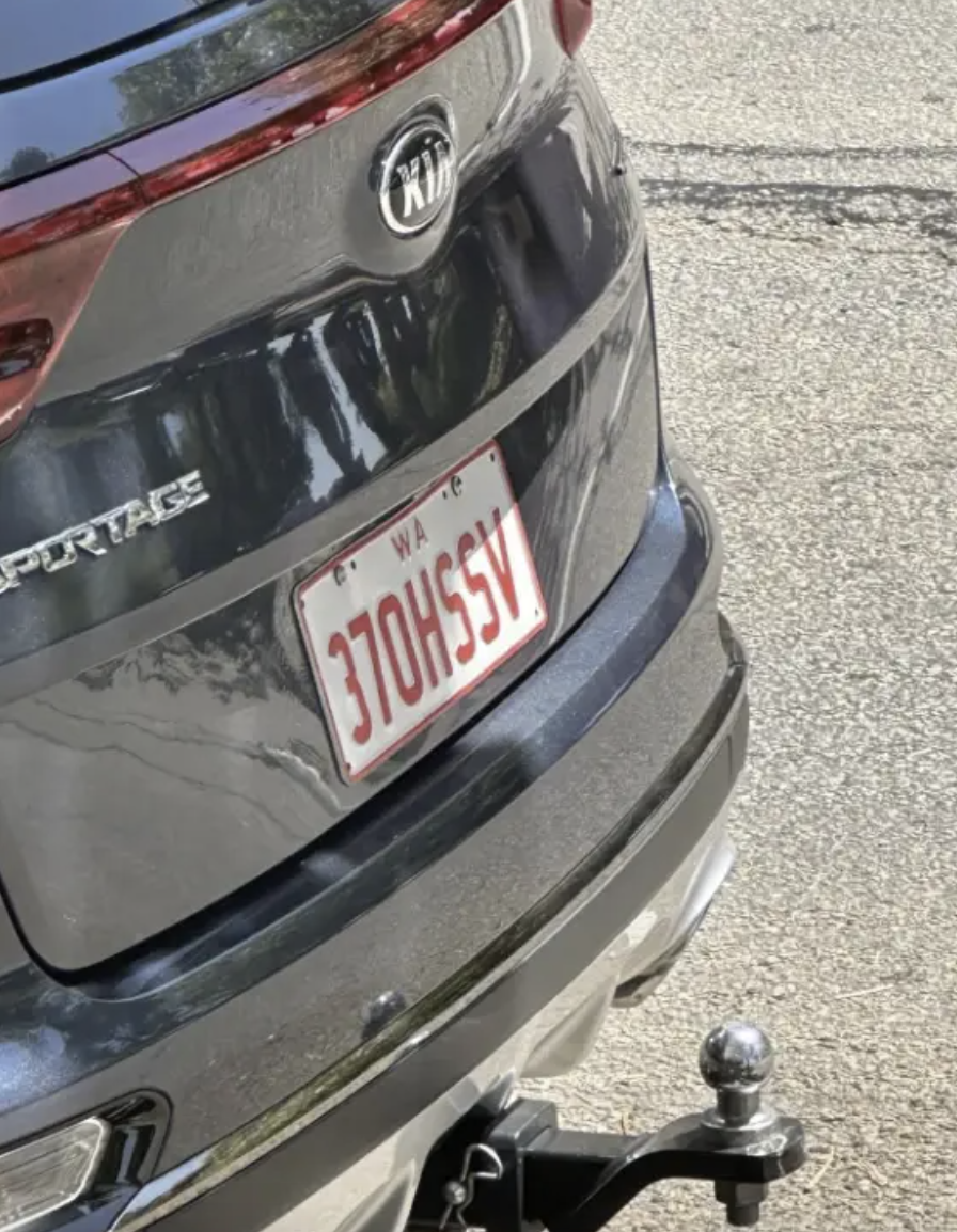 The image shows the rear of a Kia Sportage vehicle with a Washington state license plate number 370HSSV, parked on a paved surface