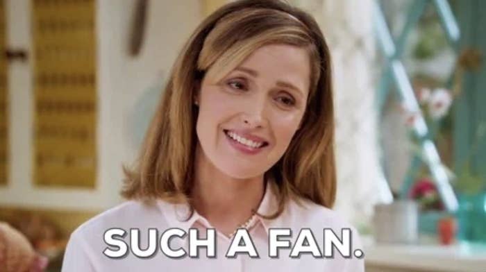Rose Byrne standing indoors, smiling, with text overlay reading, SUCH A FAN