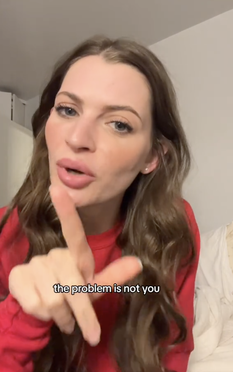 Woman with long wavy hair in a red shirt pointing her finger, caption reads "the problem is not you"