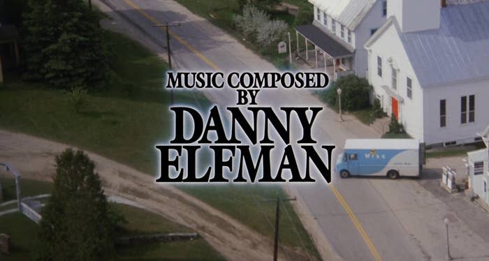"Music composed by Danny Elfman" text over a small-town scene with roads, buildings, and a mail truck