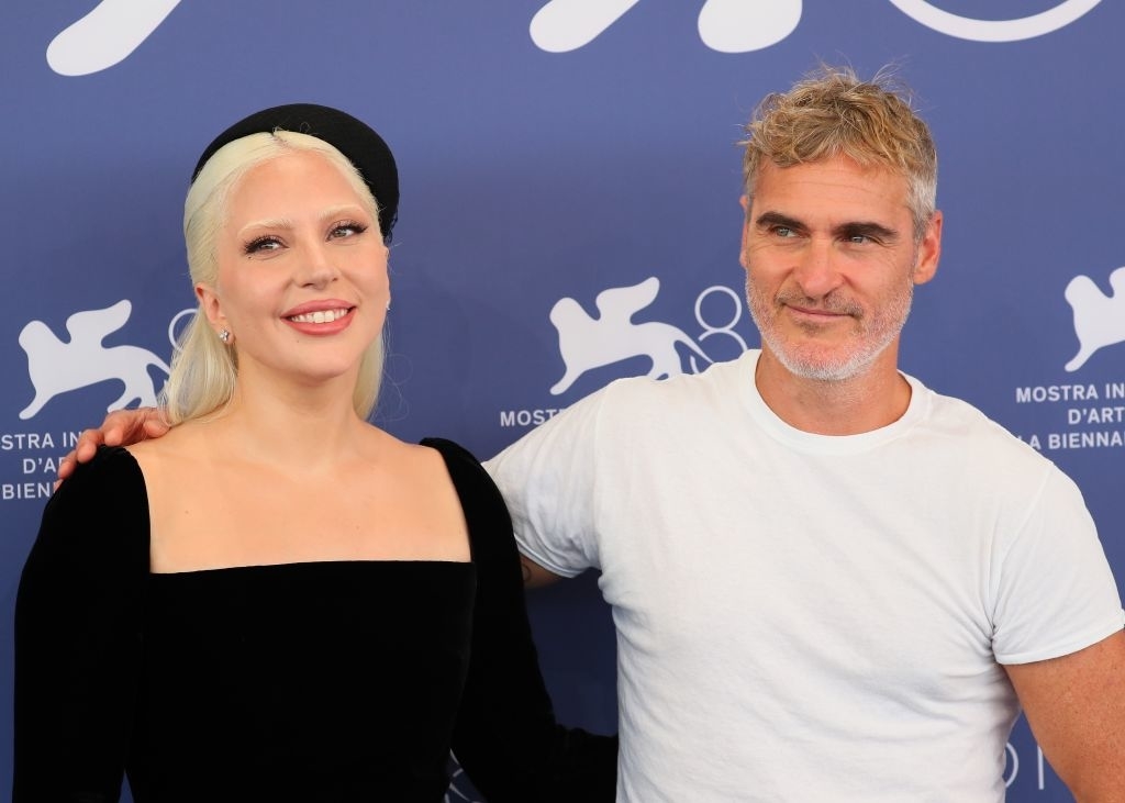 Lady Gaga in an elegant black dress and Joaquin Phoenix in a casual white t-shirt at a press event for the Venice Film Festival