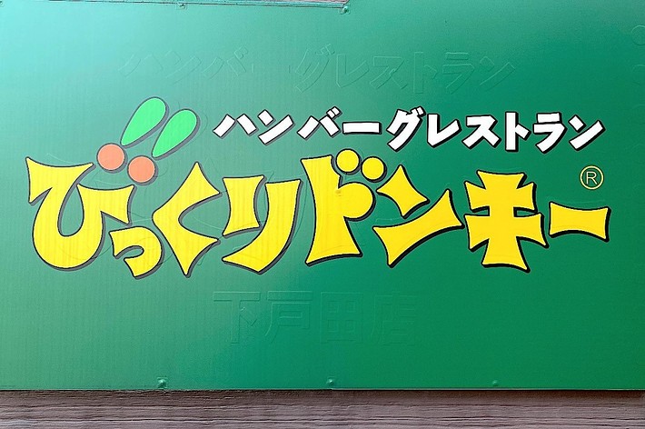 Sign for “びっくりドンキー” (Bikkuri Donkey) hamburger restaurant in bold text with playful font on a green background