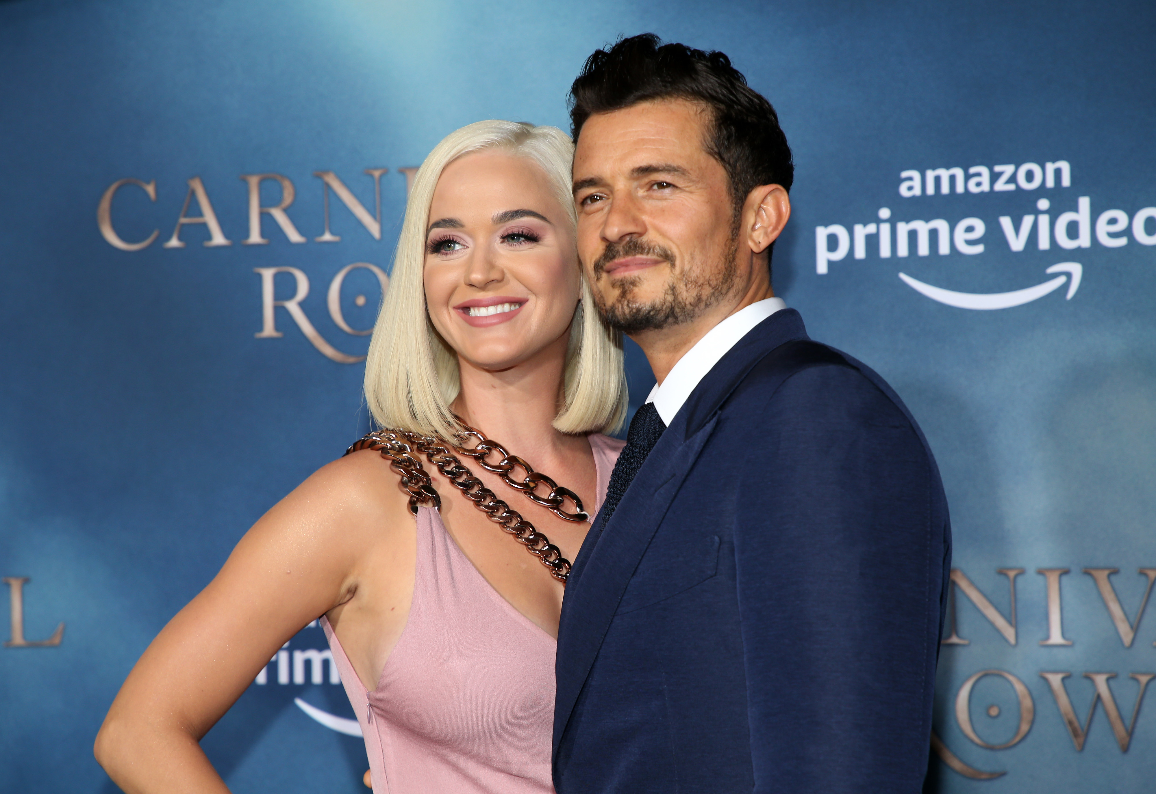 Katy Perry in a sleeveless dress and Orlando Bloom in a suit pose together at the "Carnival Row" premiere