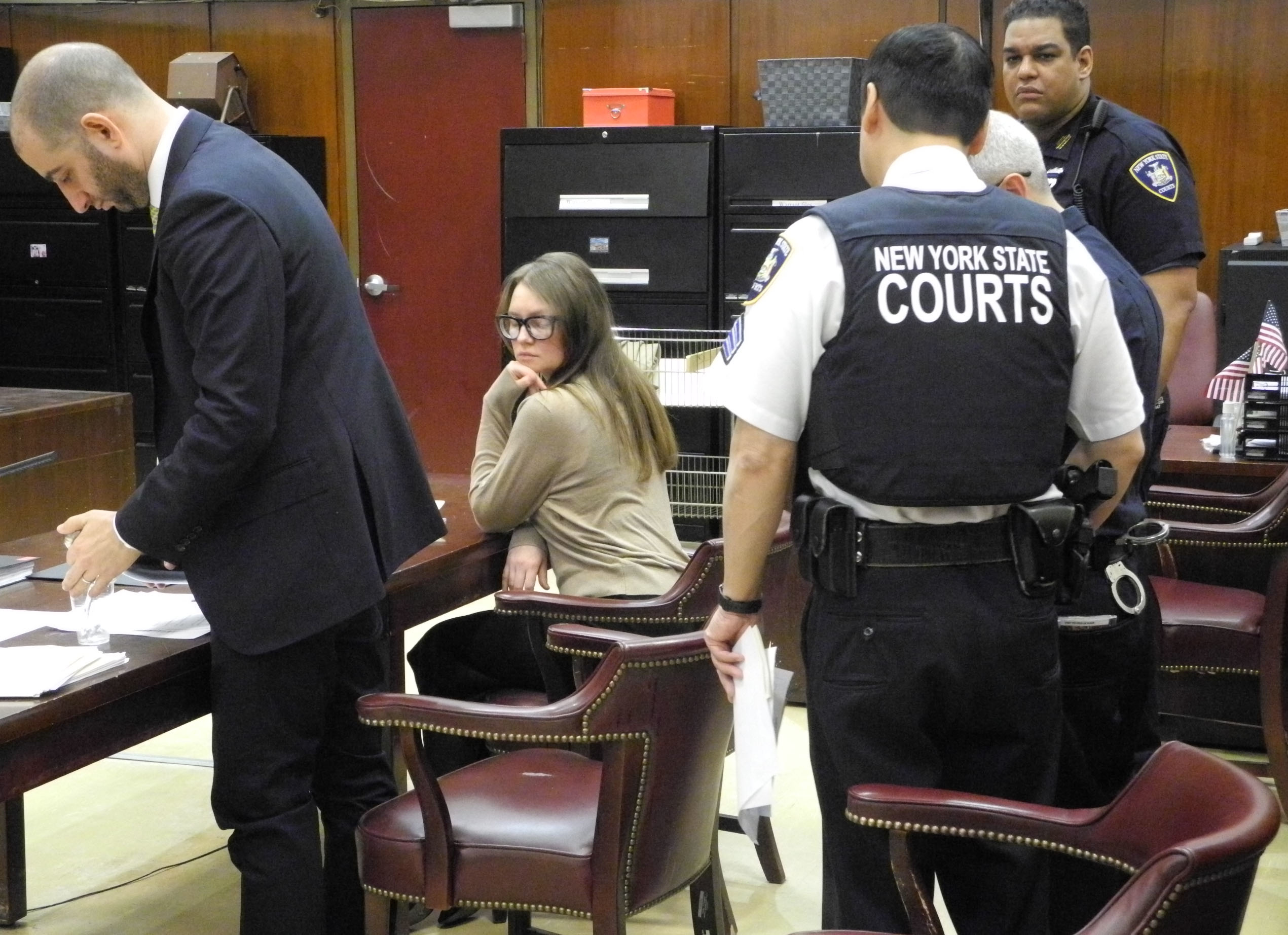 Anna Sorokin sits in court with her defense team and New York State court officers during her trial