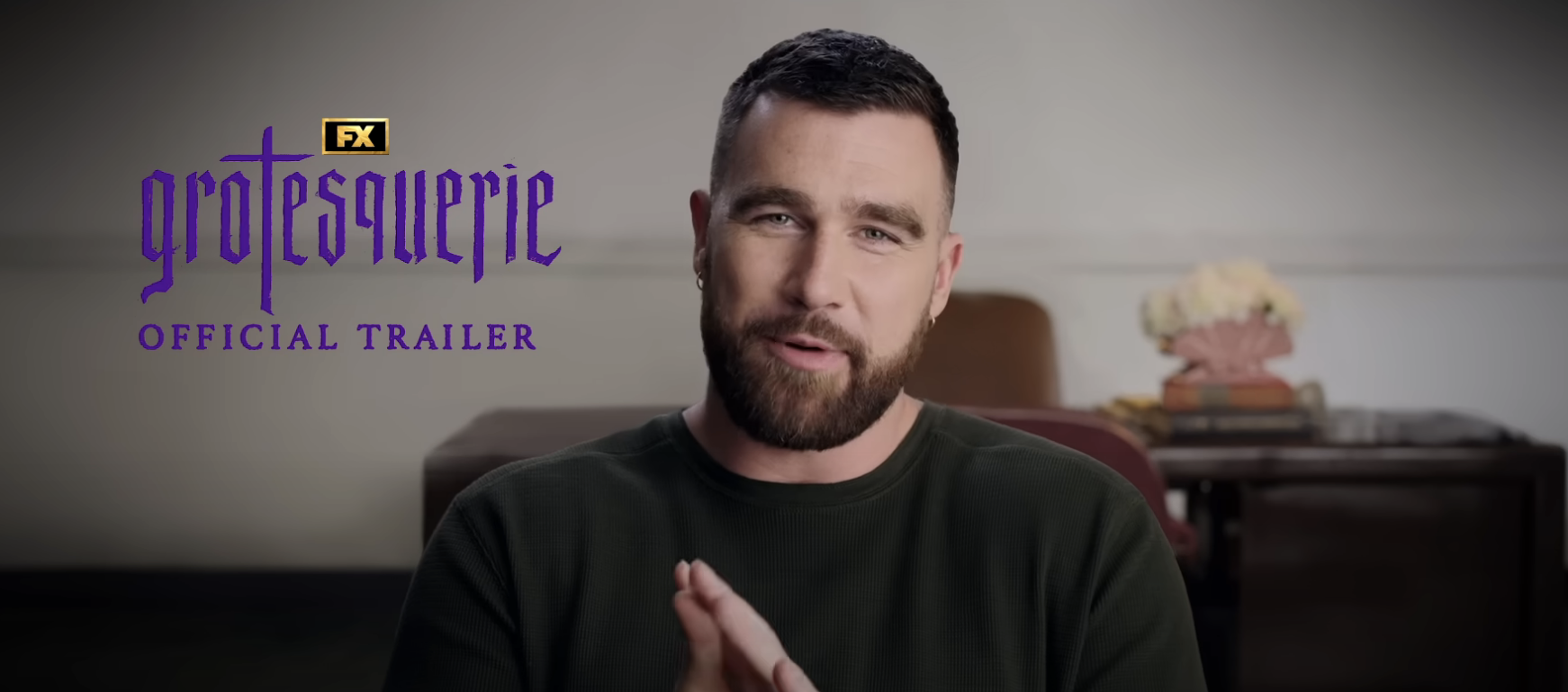 Bearded man in green sweater speaking in front of a wall. Text reads: FX Grootesquerie Official Trailer