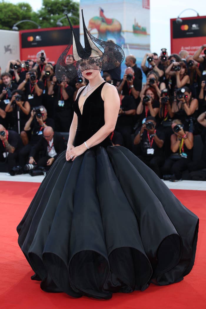 Lady Gaga on the red carpet in an avant-garde gown with a voluminous skirt and a dramatic headpiece