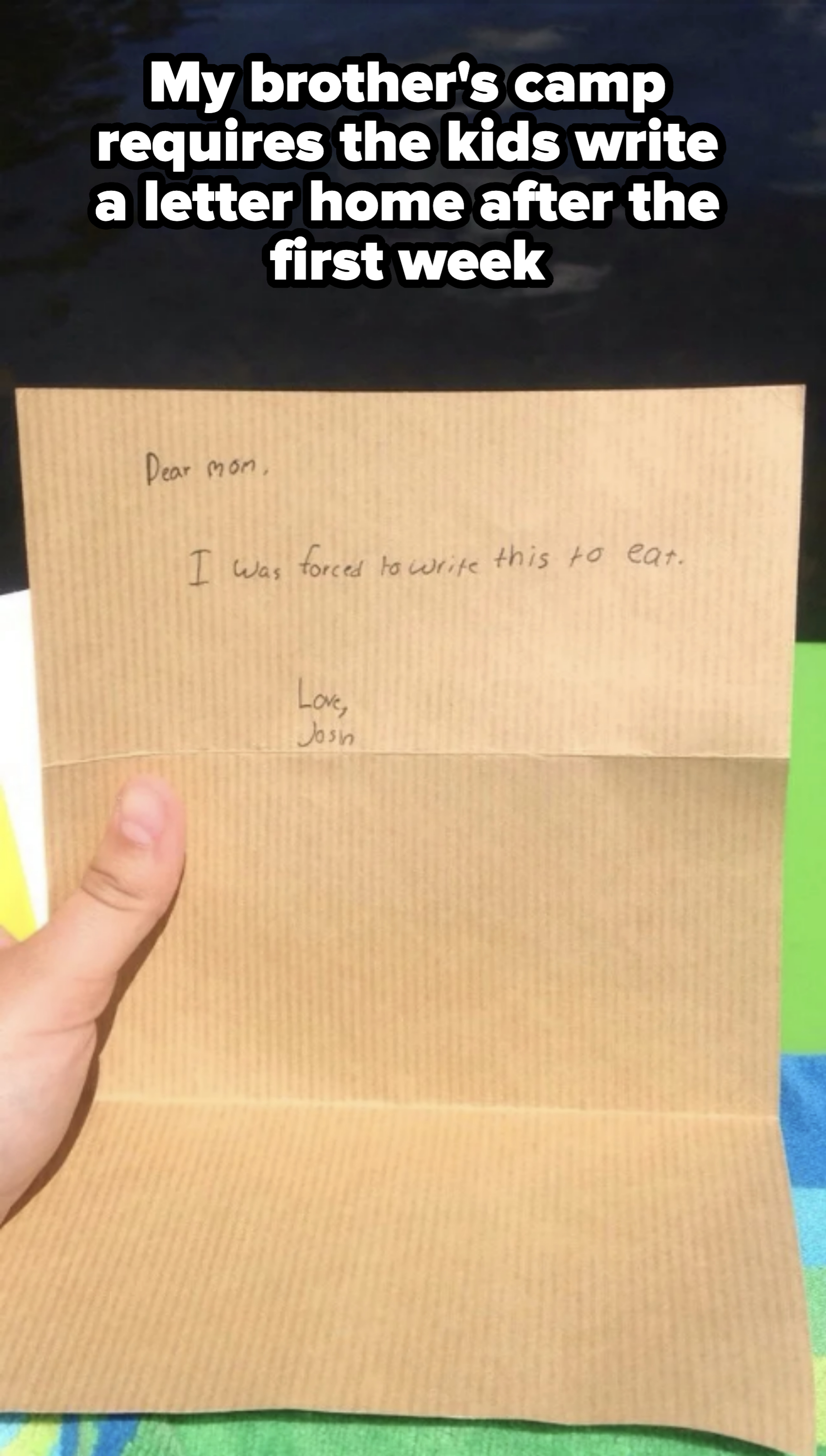 Close-up of a handwritten letter reading, "Dear mom, I was forced to write this to eat. Love, John." The letter is held by an unidentified person