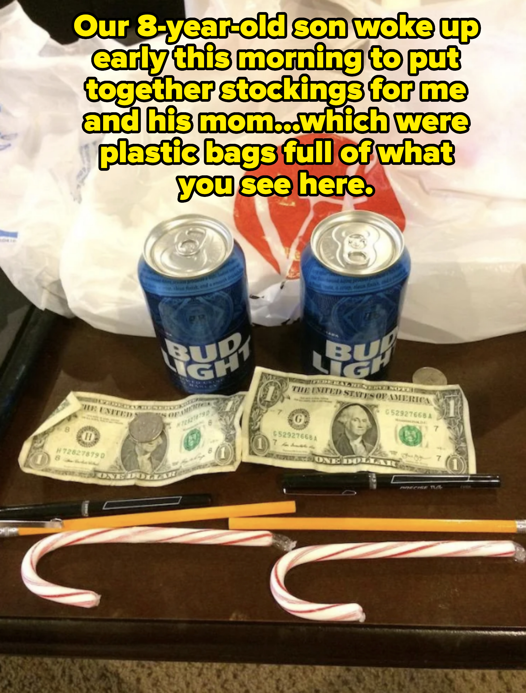 Two Bud Light cans, a CVS plastic bag, two one-dollar bills, pens, pencils, candy canes, and various items on a table