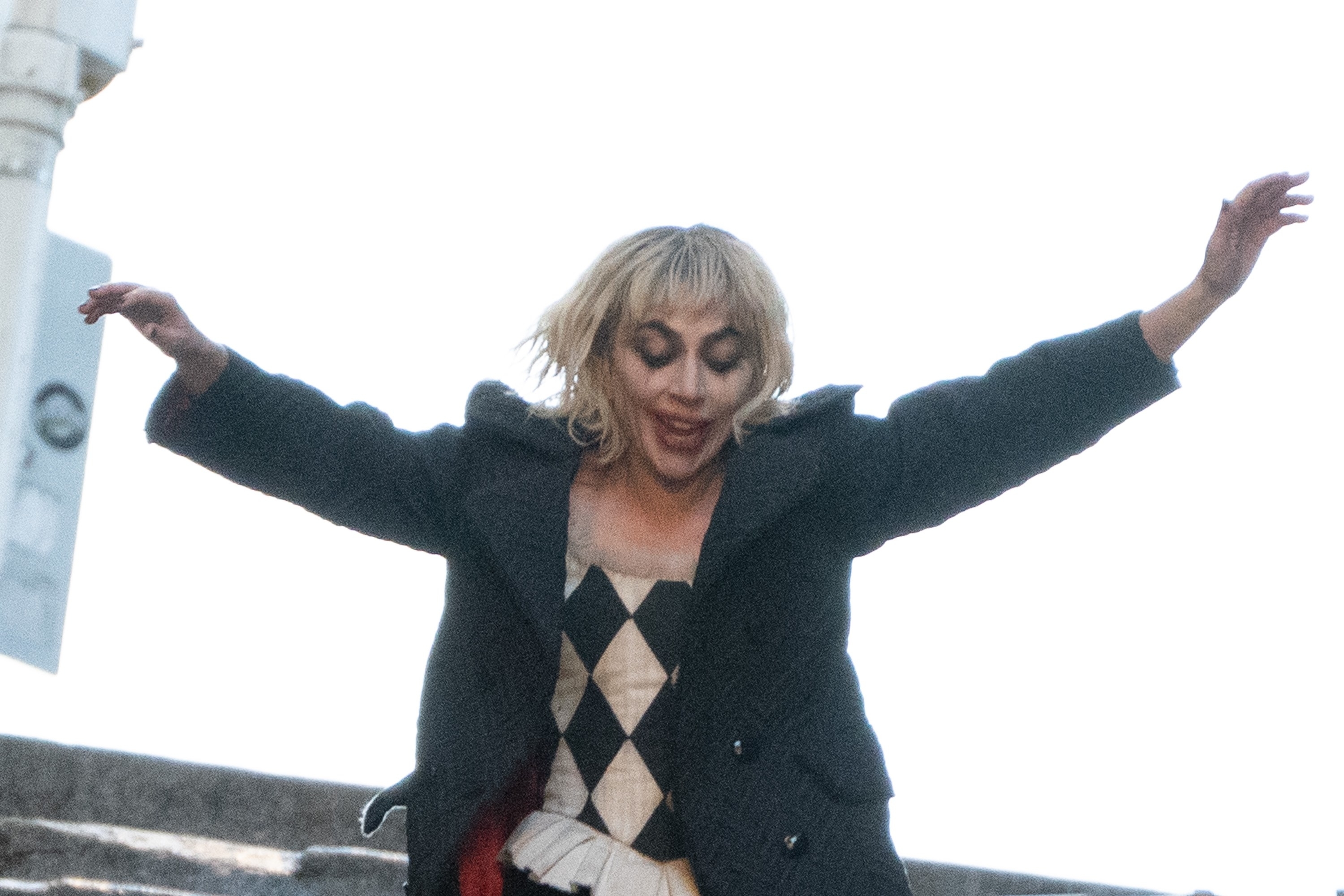 Lady Gaga in a harlequin outfit with arms outstretched