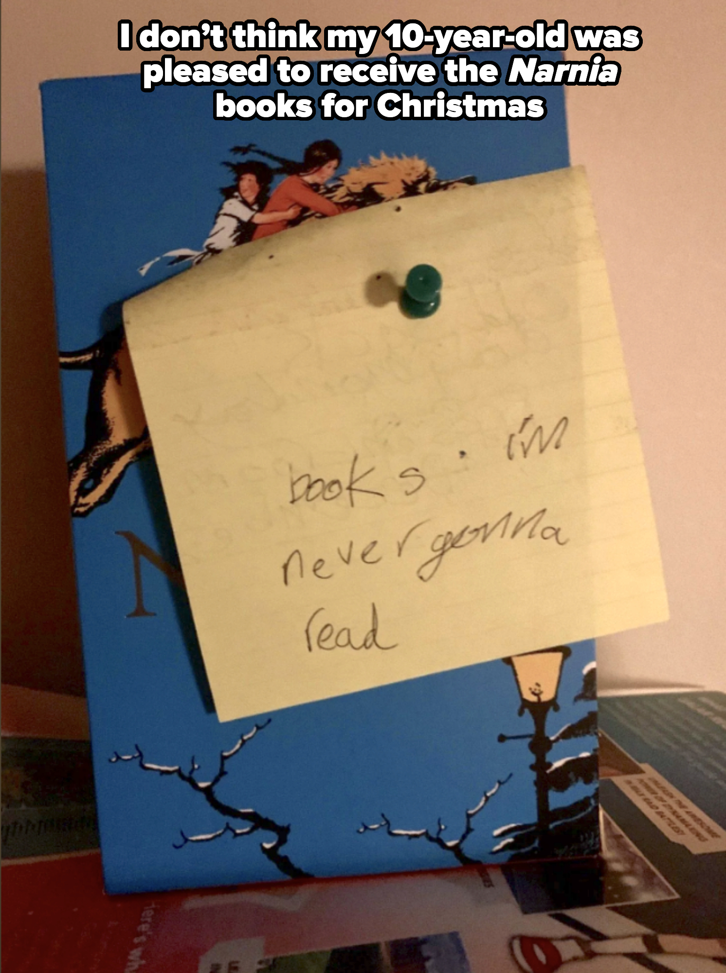 A book with a sticky note pinned on it, reading "books I'm never gonna read"