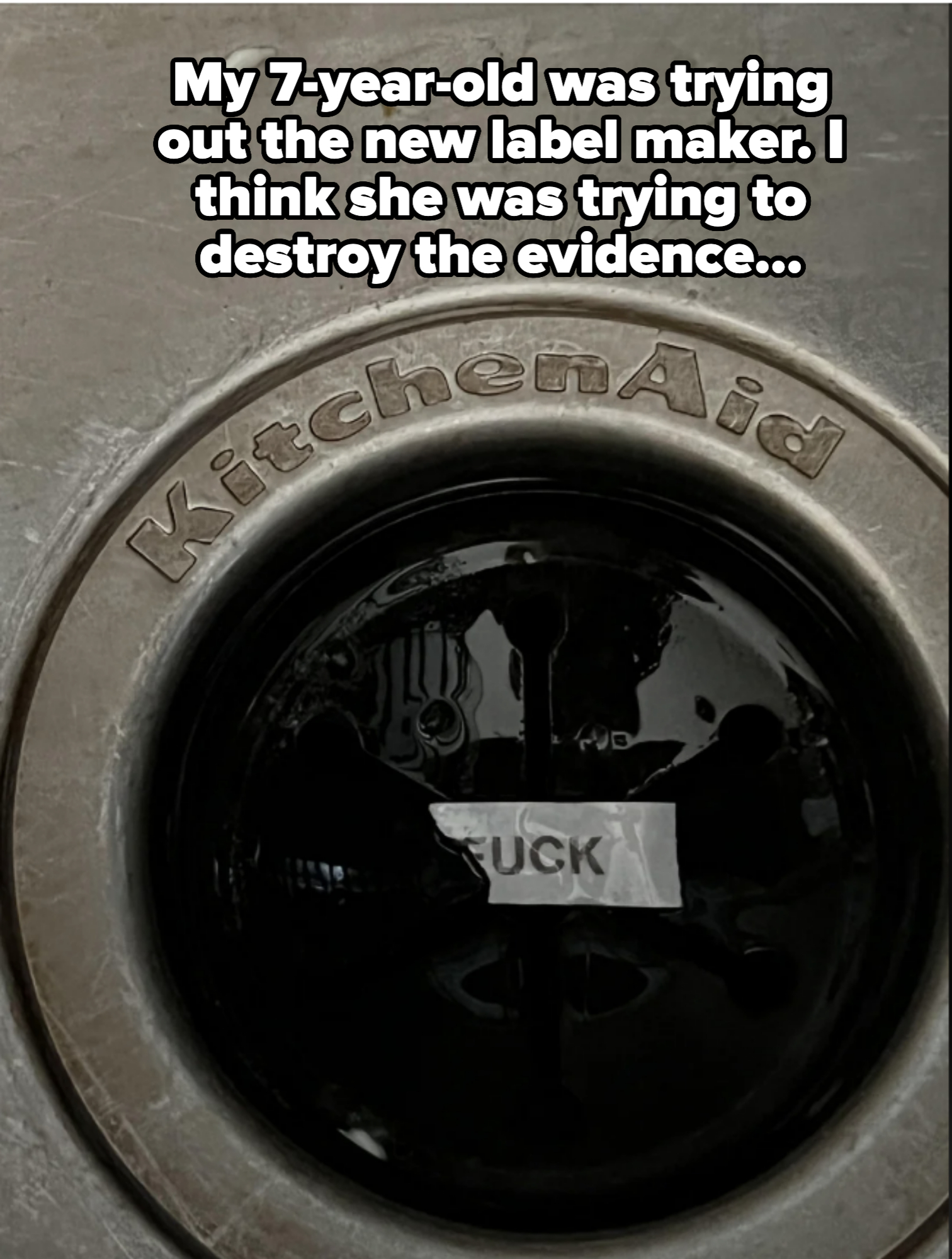 Close-up of a KitchenAid garbage disposal with a label inside reading "UCK"