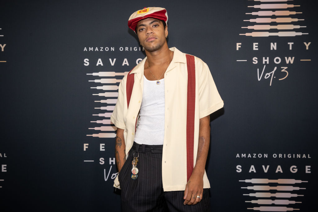 Christian Combs at the Savage x Fenty Show Vol. 3 event, wearing a casual shirt with stripes, white tank top, and hat