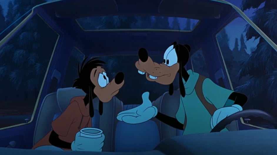 Max holding a cup looking concerned while Goofy is talking to him in a car.