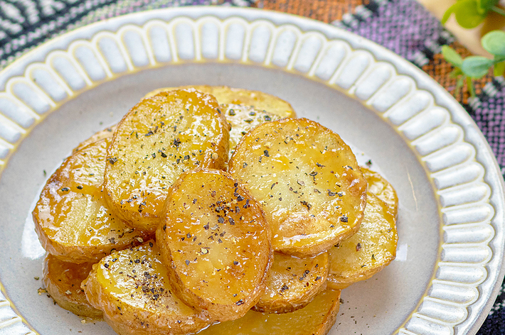 おしゃれな皿に盛られた、香辛料がかかった焼きジャガイモ。