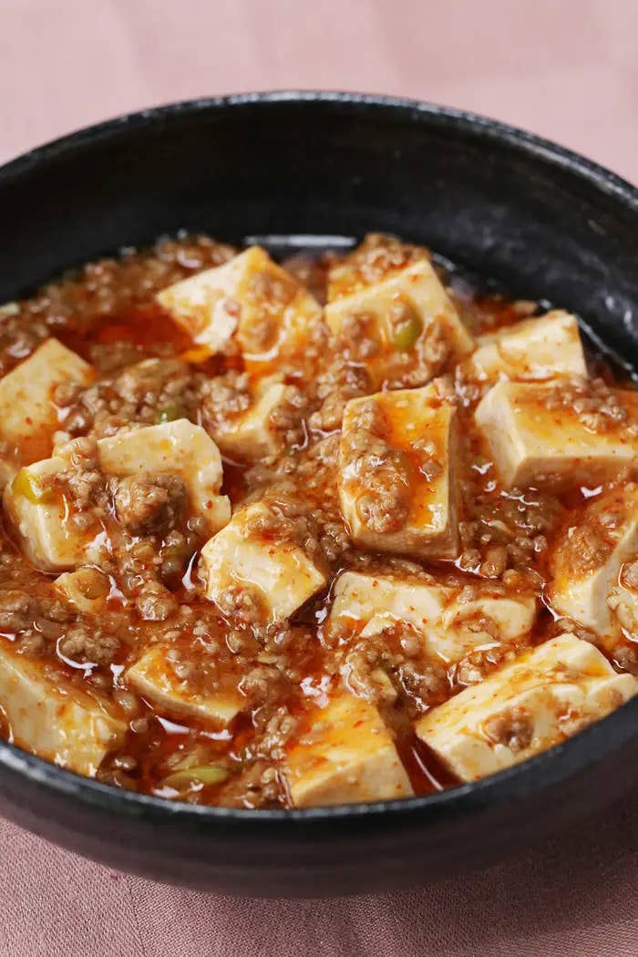 黒い器に盛られたマーボー豆腐のクローズアップ。