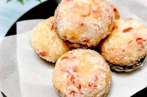お皿に盛られた数個の揚げた菓子が白い紙の上に置かれている。