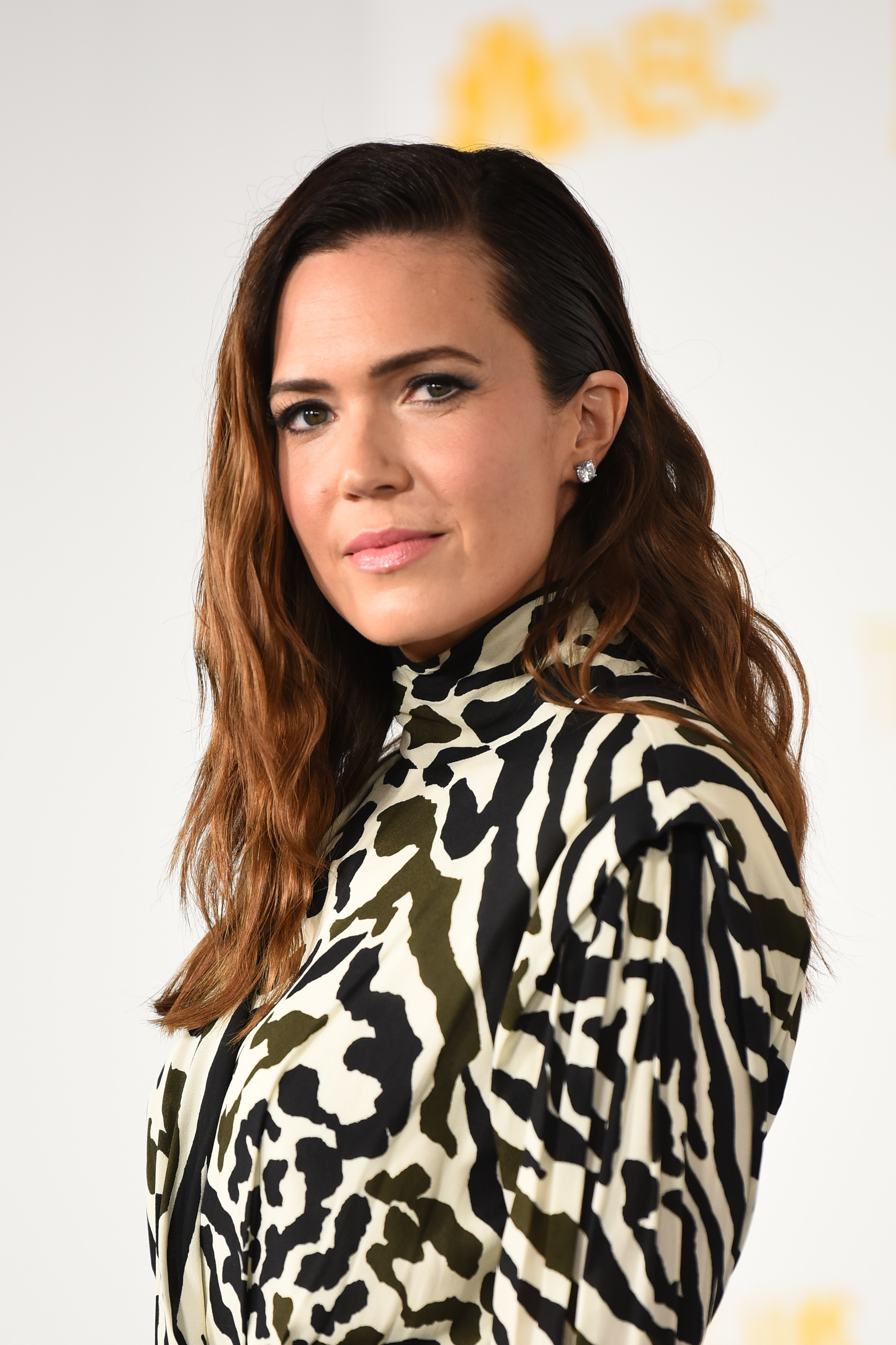 Mandy Moore posing in a patterned dress with a high collar at an event