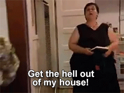 A person in a black dress stands indoors, holding a book and shouting, with the text "Get the hell out of my house!" at the bottom of the image. Names unknown