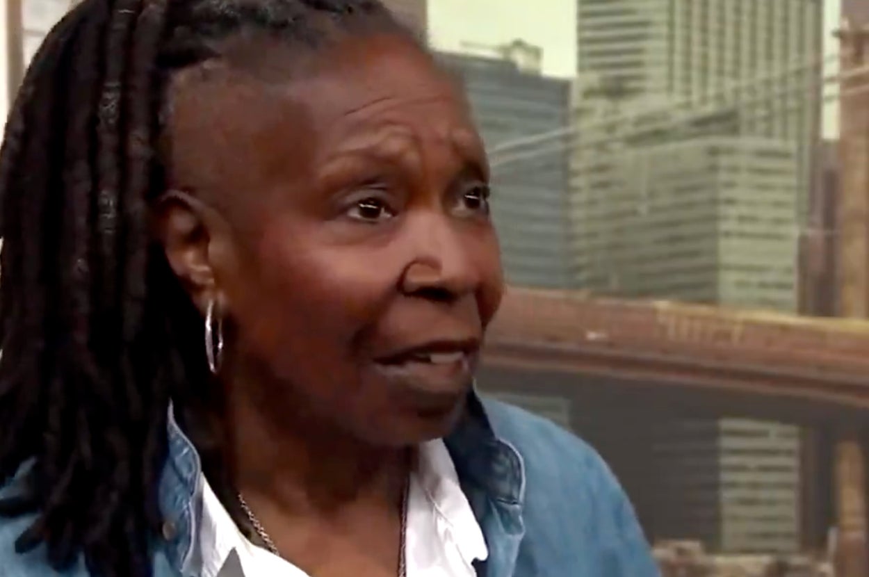 Whoopi Goldberg in a patterned coat, walking with a man in a checked jacket