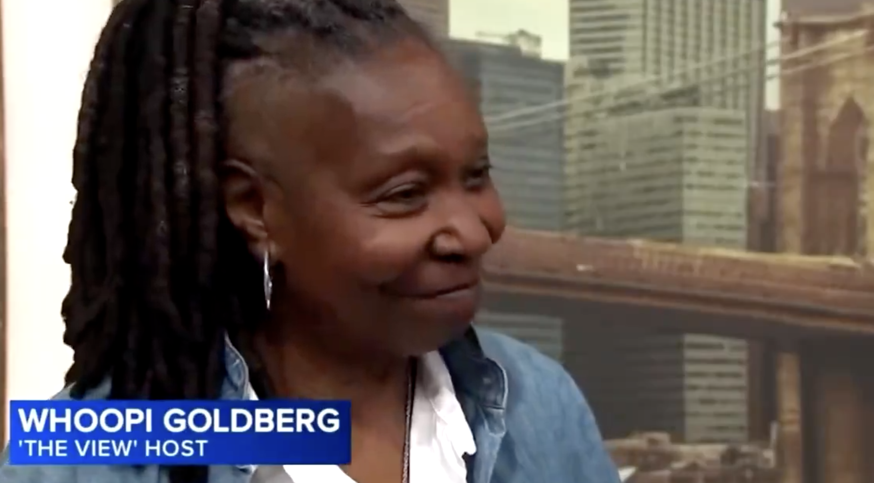 Whoopi Goldberg, 'The View' host, smiles during an interview with a cityscape background