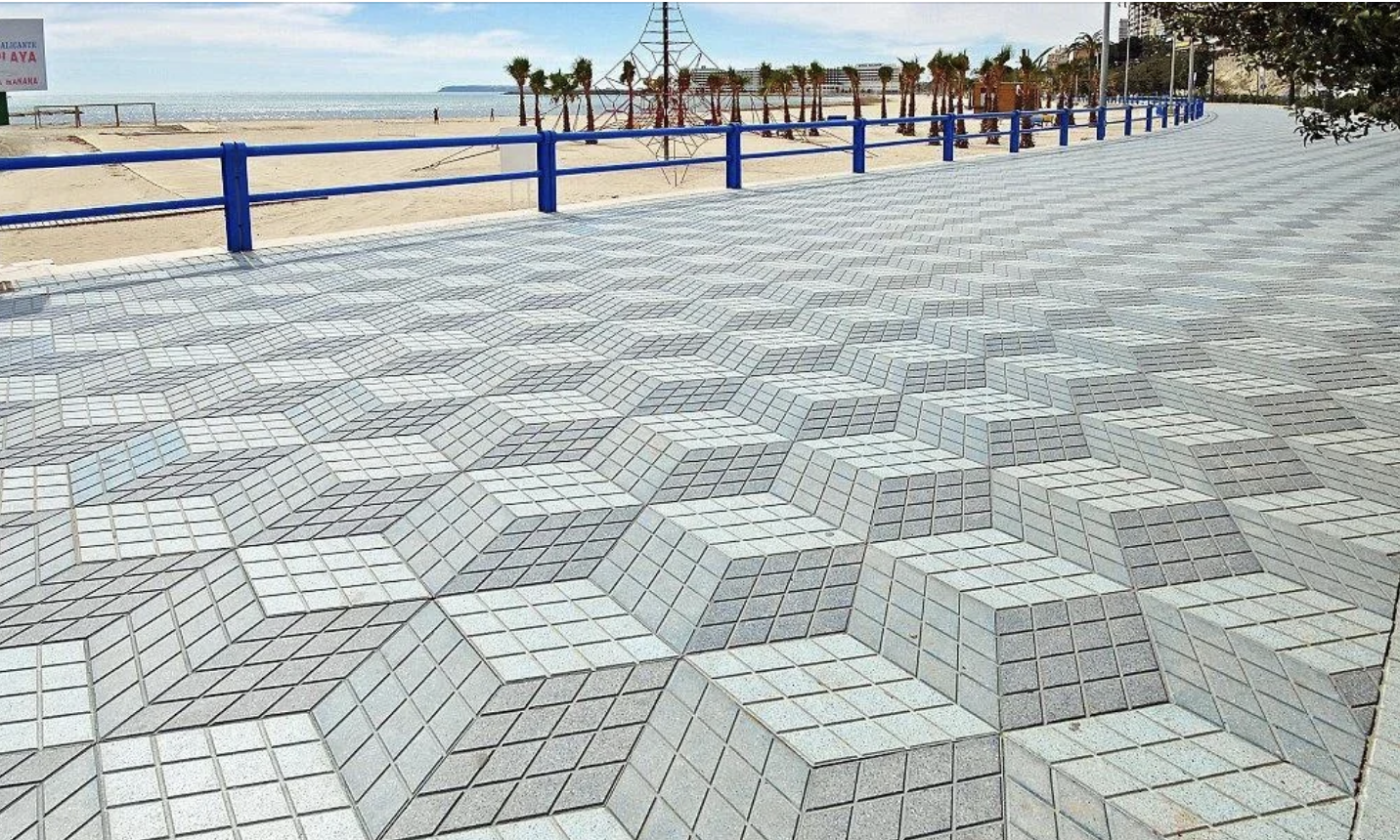 Optical illusion created by intricate pavement design on a seaside promenade