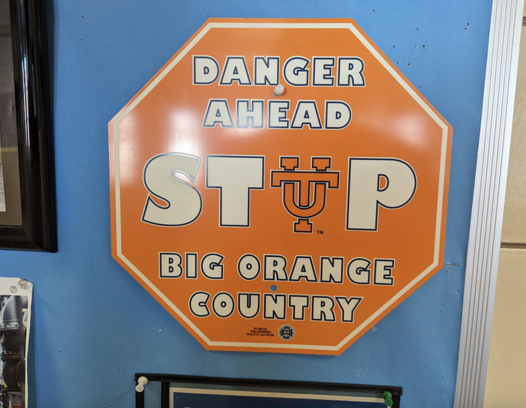 Orange sign with an octagon shape that reads "Danger Ahead, Stop Big Orange Country."