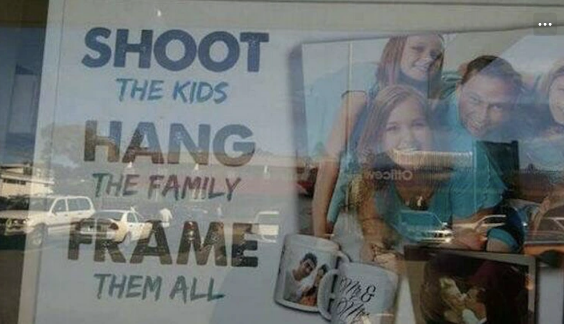 A sign in a window reads: "Shoot the kids, hang the family, frame them all," with different images, including a family photo, a mug, and a framed picture